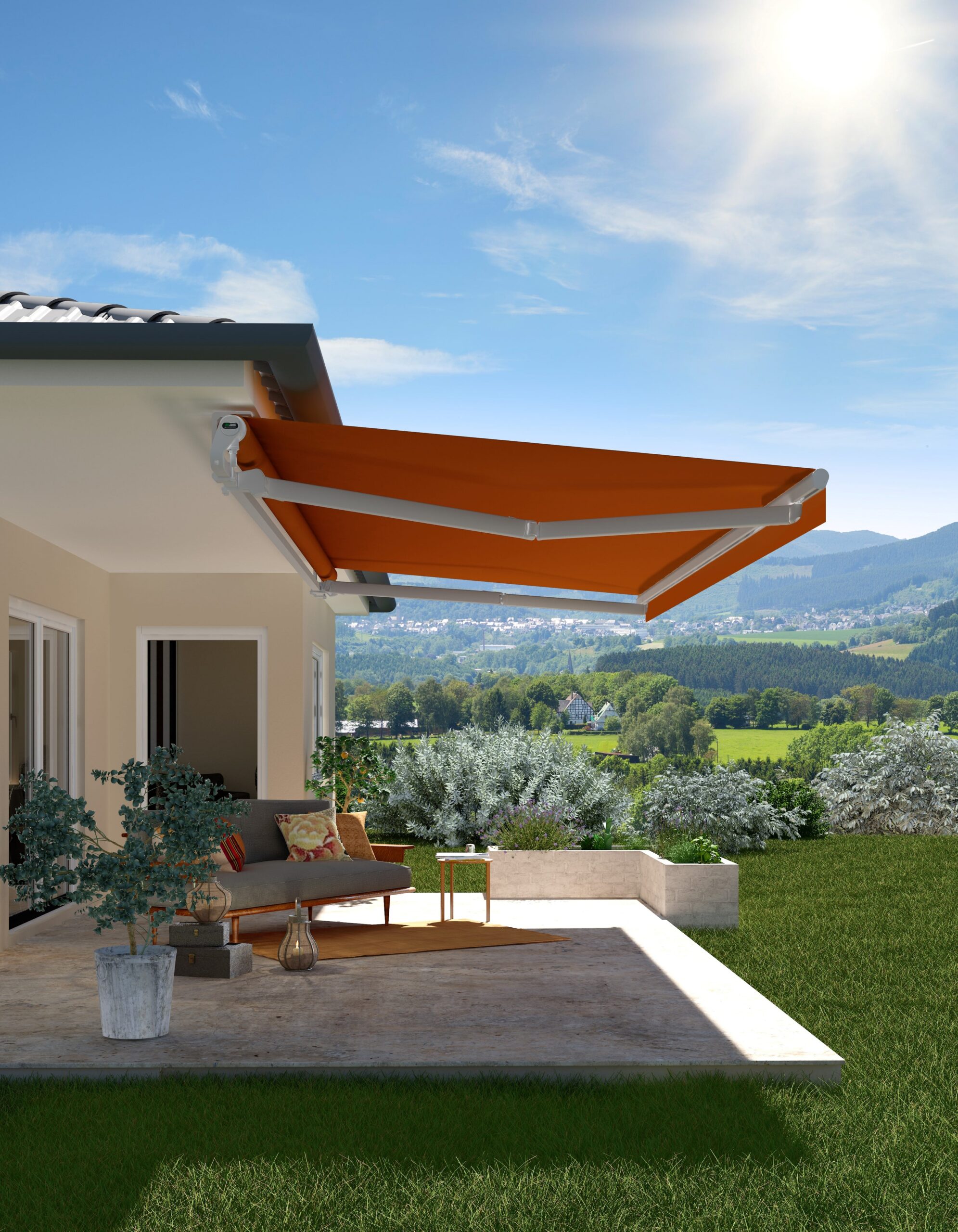 Eine orangene Markise, die an einem beigen Haus befestigt ist und eine Terrasse überdacht. Auf der Terrasse stehen Gartenmöbel und Pflanzen. Im Hintergrund ist Natur zu sehen.
